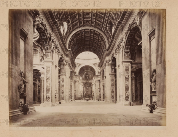 Interior of St. Peter's Basilica in Vatican City, album page, photograph, This photo is part of an album., inscription: '175 CHIESA DI S PIETRO', St. Peter's Basilica, 1870 - c. 1895, photographer, Vatican City, paper, pasteboard, albumen print, height 200 mm x width 258 mm, interior of church, A wide interior view of a grand church nave with a coffered barrel-vaulted ceiling and large arched openings along the sides, flanked by tall fluted columns and richly decorated pilasters with sculpted reliefs and statues set into niches, ornamental cornices and carved capitals; the central aisle leads toward an ornate baldachin and altar area visible in the distance, with layered arches and detailed ornamentation above, while figures of sculpted saints and decorative angels occupy many of the vertical surfaces and pedestals, and the stone floor shows a patterned surface extending to the foreground.