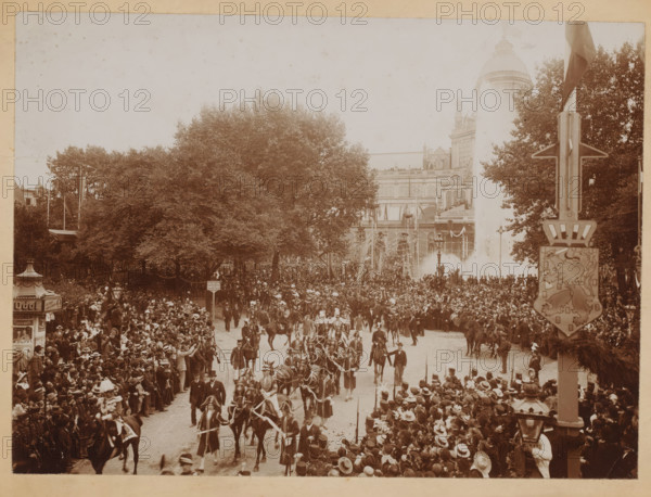 Carriage with Princess Wilhelmina and Queen Mother Emma, Frederiksplein, Amsterdam, photograph, Carriage with Princess Wilhelmina and Queen Emma on September 5, 1898, at Frederiksplein in Amsterdam. After arriving at Weesperpoort Station, they take a tour through the city. Procession drives into Utrechtsestraat (?). In the background the Palace of Popular Industry, which would burn down in 1929. Wilhelmina is inaugurated on Tuesday, September 6, 1898., stamp: 'ADR. FAVIER, CIGAR WAREHOUSE, KONINGSPLEIN 16, AMSTERDAM', photographer: Coral & Co., Guy de, vendor: AA Favier, 1898-09-05, paper, daylight collodion silver print, daylight collodion silver print on photographic paper, height 163 mm, width 224 mm x width 250 mm, height 199 mm, A wide street scene crowded with people lining both sides and filling the roadway shows many figures wearing hats and formal attire, with mounted riders and horses parading down the center; large leafy trees form a canopy along the left and center backgrou...