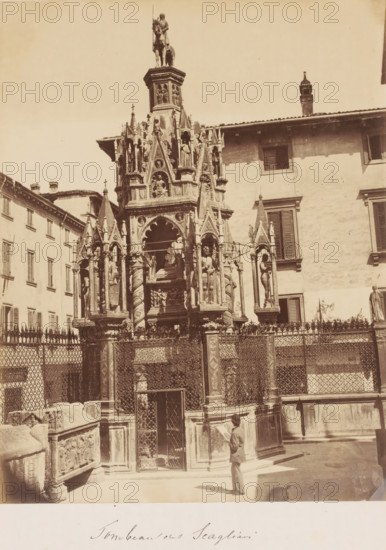 Tomb of the Scagliari family, Italy, photograph, Tomb in the city, with an ornately decorated fence and a man, tourist? with a bowler hat in front of it, reading information about the monument ?., caption: 'Tombeau ons ? Scagliari', number: '1182', inscription: '1860's BRESSANINI', c. 1865 - c. 1880, photographer, pasteboard, paper, albumen print, albumendruk, height 280 mm x width 218 mm, height 415 mm x width 300 mm, A tall ornate stone monument with multiple pointed arches, sculpted figures, and decorative columns rises from a fenced base in a courtyard, surrounded by buildings with shuttered windows; the monument features a mounted figure at its highest point, niches with statues, carved reliefs, and intricate metalwork on the surrounding railing, while a person in a suit and hat stands near the base looking up.