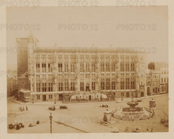 Aachen City Hall after the fire', Germany, photograph, 'Aachen City Hall after the fire', Germany., number: '19 (in the same ink, handwriting as inscription verso) with number: 38 written in pencil over it', inscription: 'Stadhuis v. Aken na den brand', in or after 1883 - c. 1910, photographer, pasteboard, paper, albumen print, albumendruk, height 180 mm, width 230 mm x width 381 mm, height 304 mm, North Rhine-Westphalia, Aachen, A wide sepia-toned photograph of a large ornate stone building with many tall rectangular windows and decorative stonework across its façade, a broad central staircase with balustrades leading to an entrance, lamp posts along the street in front, a multi-tiered circular fountain with water basins and surrounding railings in the square, a tall tower attached to the left side of the building and smaller adjoining structures on the right, several small groups of people and a few horse-drawn vehicles scattered on the open paved area, and various architectural deta...