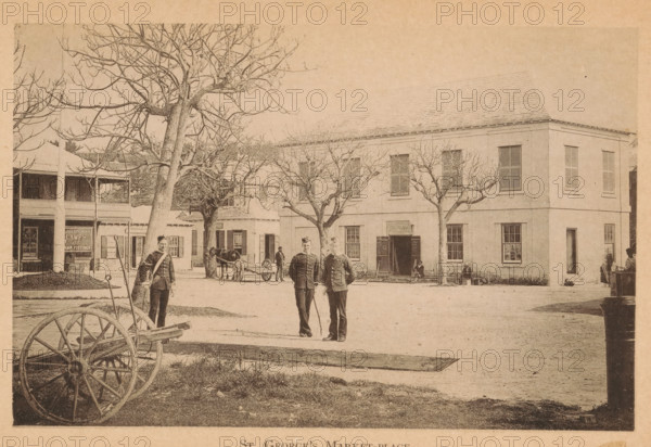 St. George's market-place, page, photomechanical print, photographer: James H. Stark, Saint George, cliché maker: Photo-Electrotype Company, Boston (Massachusetts), c. 1879 - in or before 1884, James H. Stark, Photo-Electrotype Company, photographer, cliché maker, North America, Massachusetts, Bermuda, paper, collotype, photoprint, height 98 mm x width 151 mm, Print on frontispiece., market, village square, A sepia-toned street scene shows a large two-story building with multiple shuttered windows and a pitched roof, flanked by leafless trees in front. In the foreground there is a wooden wagon wheel and cart frame on a patch of grass, and three uniformed men standing on the dirt street near the center, two standing together and one slightly apart. To the left a two-story porch building is visible with an open storefront beneath the upper balcony. A horse hitched to a small cart stands near the middle background, and a few seated and standing figures are near the building entrances. The...