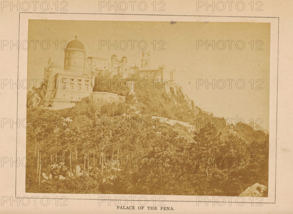 View of the Palácio da Pena in Sintra, Palace of the Pena, photograph, page, Sintra, c. 1860 - in or before 1870, photographer, paper, albumen print, height 97 mm x width 135 mm, palace, Palácio da Pena, A faded photograph mounted on a pale mat shows a hillside topped by a large ornate building with rounded towers, domes, battlements, arched openings, and decorative stonework, with a dense stand of trees and rocky terrain covering the slope below and a lighter sky occupying the upper right area.