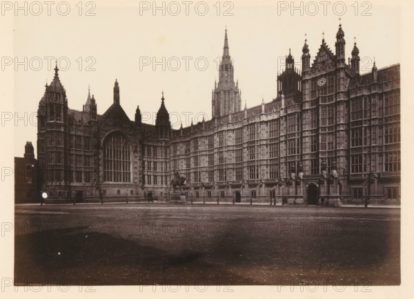 View of Palace of Westminster, north view, photograph, page, photographer: John Harrington, London, c. 1864 - in or before 1869, paper, albumen print, height 139 mm x width 195 mm, palace, Houses of Parliament, A wide sepia photograph shows an ornate Gothic stone building with tall pointed spires, decorative pinnacles, and many vertical windows set in a long facade; a large arched window with intricate tracery is prominent near the left, and a clock face is visible on a tower toward the right; a statue of a mounted figure stands on a pedestal in front of the building, with a paved open area stretching across the foreground and a few lampposts and small doorways along the base of the structure.