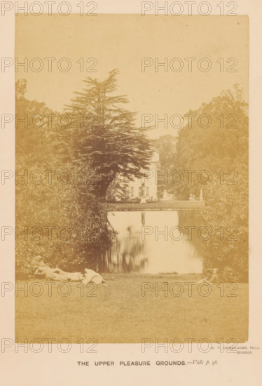 The Upper Pleasure Grounds, View of a sunbathing lawn in Moor Park in Rickmansworth, photograph, page, inscription: 'Vide p. 96.', photographer: Henri Victor Leménager, Rickmansworth, c. 1866 - in or before 1871, Hertfordshire, paper, albumen print, height 138 mm x width 98 mm, park, garden pond, A sepia-toned photograph showing a grassy foreground with two people reclining near the lower edges, a reflective body of water stretching toward the middle ground, dense trees and large shrubbery flanking both sides, a tall coniferous tree partially obscuring a multi-story building with visible windows and architectural details in the background, and the building’s reflection visible in the water.