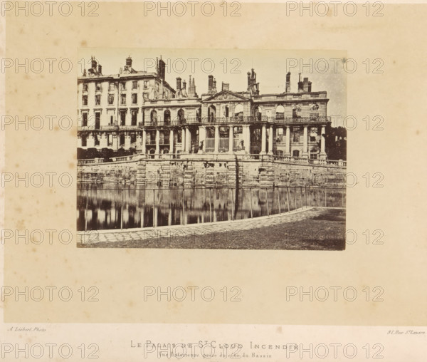 View of the Château de Saint-Cloud after the fire caused by the Paris Commune, Le Palais de St. Cloud Incendié. Vue Extérieure prise du côté du Bassin, photograph, page, address: '31, Rue St. Lazare', number: '(No. 59)', photographer: Alphonse-Justin Liébert, Saint-Cloud, 1871 - 1872, paper, albumen print, height 98 mm x width 131 mm, ruin of a building, architecture, castle, garden pond, Paris Commune (1871), Château de Saint-Cloud, A sepia-toned photograph shows a large neoclassical building with a colonnaded façade and an ornate central pediment, rows of tall windows, and multiple chimneys and roof structures, positioned behind a stone balustrade and a stepped retaining wall that borders a reflective water surface in the foreground; a paved walkway runs along the water edge and the image is set against a wide margin of aged, spotted paper.