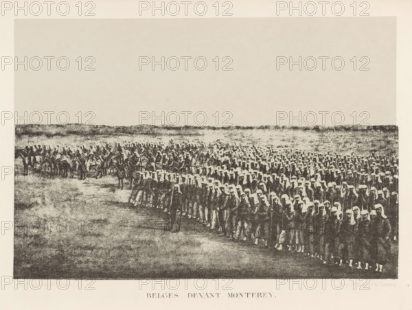 View of army troops, Belges Devant Monterey, page, photomechanical print, photographer: Capitaine Louis Delaunoy, Mexico, cliché maker: Simonau & Toovey (possibly), Brussels, c. 1867 - in or before 1872, printer (person), North America, paper, photolithography, height 114 mm x width 169 mm, assembling of military forces, mobilization, troop concentration, A wide landscape view with a large assembled group of people filling the lower half of the image, arranged in many orderly rows and wearing light head coverings and dark garments, with some individuals on horseback to the left and a low, textured horizon line stretching across the middle; the upper portion is an open, pale sky, and the ground in the foreground shows a mottled, grainy texture.