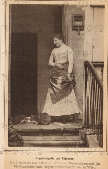 Veranda with a woman and two cats, page, photomechanical print, inscription: 'Nach einer Naturaufnahme für pmologische Studien', photographer: KK Lehr- und Versuchsanstalt für Photographie, cliché maker: Wilhelm Hoffmann AG, c. 1886 - in or before 1891, paper, collotype, photoprint, height 141 mm x width 95 mm, Print on sixth unnumbered page after page 627., historical persons - BB - woman, cat, A sepia-toned photograph showing a woman standing in a doorway wearing a long patterned dress with a checked apron; she has her head slightly bowed and one hand rests at her waist while the other holds the apron. She stands on a worn stone threshold beside a wooden railing and a vertical post with a mounted box-like fixture. Two cats are at her feet on the step near a shallow dish, their bodies low and facing the dish. The scene includes a dark interior behind the woman and textured walls around the doorway.
