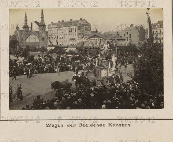 Wagon of visual arts, photograph, page, Antwerp, c. 1899, photographer, paper, printing, height 98 mm x width 152 mm, civic architecture, edifices, dwellings, animal traction, animal-drawn vehicle (carriage etc.), festivities (decorated float, wagon, festive activities), A large crowd of people wearing hats fills a cobblestone street around an ornate parade float adorned with multiple statues and decorative elements, horses hitched to the float are visible in front, several people in period clothing walk alongside and stand near the float, a dense cluster of trees and foliage appears on the right edge, behind the crowd a row of multi-story buildings with detailed façades and large windows lines the background, a grand building with tall spires and an arched entrance is visible toward the left, flags and banners hang from some buildings, carriages and groups of onlookers occupy the middle ground, and lamp posts and street furniture are scattered throughout the scene.