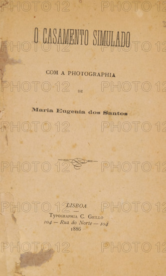 O casamento simulado com a photographia de Maria Eugenia dos Santos, book, typographer: C. Grillo, Lisbon, 1886, paper, printing, albumen print, height 228 mm x width 141 mm x thickness 6 mm, A vertically oriented aged paper page with a warm tan tone and scattered darker spots and stains, edges showing wear and small tears with a larger darker stain near the lower left margin, a decorative flourish centered above the lower third, and multiple areas of uneven discoloration across the surface.