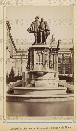 Brussels. Statues of the Counts of Egmont and Horn, Statue of Egmont and Horn on the Petit Sablon in Brussels, photograph, page, Brussels, c. 1875 - c. 1880, photographer, paper, albumen print, height 171 mm x width 102 mm, Person, Philip of Montmorency (Count of Horne), Lamoraal Count of Egmond, monument, statue, ornamental fountain, A sepia-toned photograph of a large ornate stone fountain topped by two standing male statues dressed in historical attire, one with a feathered hat and the other holding a hat at his side, both draped in capes and positioned close together on a high pedestal carved with decorative panels and reliefs; the fountain basin in front shows smooth rounded tiers and water flowing into the lower pool, while the pedestal sides feature additional sculpted figures in niches and ornamental motifs; behind the monument a classical building facade with columns, windows, balustrades, and sculptural roof details is visible, framed on the left and right by trimmed shrubs a...