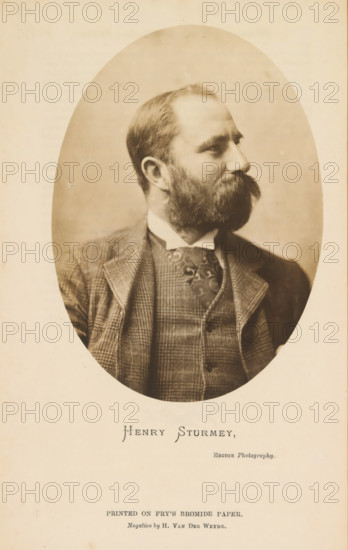 Henry Sturmey, Portrait of Henry Sturmey, photograph, page, inscription: 'Editor Photogrpahy, Printed on Fry's Bromide Paper', photographer: Henry van der Weyde, c. 1886 - in or before 1891, Henry van der Weyde, photographer, paper, gelatin silver print, developing gelatin silver print on Fry's Bromide Paper, height 137 mm x width 99 mm, Person, historical persons, A sepia oval portrait of a bearded man shown in three-quarter profile looking to the side, wearing a patterned suit jacket, waistcoat, high-collared shirt, and patterned tie, set against a plain backdrop and framed by a lighter rectangular border.
