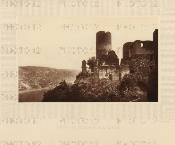 Ruins of Schoenburg, Rhine, View of the ruins of Schönburg at Oberwesel, page, photomechanical print, inscription: 'England photo.', inscription: 'Europe', photographer: William England, Oberwesel, cliché maker: Woodbury Permanent Photographic Printing Company, c. 1870 - in or before 1875, Rhineland-Palatinate, paper, pasteboard, Woodburytype, Woodburytypepie, height 97 mm x width 158 mm, ruin of a dwelling, house, castle, Schönburg, A sepia-toned photograph framed by a textured mat shows a hillside with stone ruins and a cylindrical tower rising above crumbling walls, adjacent rounded battlements and fragmented masonry, vegetation growing among the stones and along the slope, a narrow path with simple wooden railings winding beside the ruins, a river visible at the base of the hill and terraced fields on the opposite bank, and a pale sky occupying the upper portion of the image.