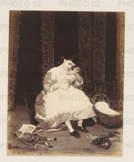 Photo reproduction of La poupée by Florent Willems, photograph, reproduction, page, after painting by Florent Willems, c. 1858 - c. 1863, photographer, paper, albumen print, albumendruk, height 141 mm x width 114 mm, picture, painting, girl (child between toddler and youth), (playing with) dolls, A seated young girl in a light-colored dress with lace trim holds a bundled doll to her chest and leans her head to one side; she wears dark shoes and light stockings and has a ribbon in her hair. She sits on a cushioned surface in front of a dark patterned curtain with vertical decorative panels. A woven basket with a cloth inside rests beside her on the floor. Scattered on the floor in front of her are a toy soldier or puppet with ornate clothing, a small musical instrument, a folded piece of fabric with patterns, and an open book. The image has a pale border around the central scene.