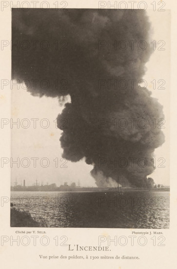 Fire in a hangar with oil after the explosion of a munitions factory in Oosterweel near Antwerp on September 6, 1889, L'Incendie, page, photomechanical print, number: '4', inscription: 'Vue prize des polders, à 1300 mètres de distance.', photographer: Victor Selb, Oosterweel, cliché maker: Joseph Maes, 1885-09-06 - 1889-12-12, Victor Selb, Joseph Maes, photographer, cliché maker, paper, collotype, photoprint, height 165 mm x width 120 mm, smoke, burning, Explosion of a munitions factory in Oosterweel in 1889, A large, dark column of smoke rises from the shoreline and fills most of the upper part of the scene, with billowing, cloudlike edges and varying shades of gray; along the horizon a low strip of land shows silhouettes of masts, smokestacks, and small buildings; the water in the foreground reflects light and has a rippled texture; at the base of the smoke near the shore there are a few small, indistinct boats and shapes.