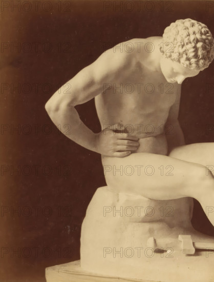 Sculpture of a man and a sword by Leopold Borbone, photograph, This photograph is part of a cover with 18 photographs on 18 sheets and 14 text sheets., photographer: Grillet jeune (possibly), c. 1854 - in or before 1859, paper, albumen print, height 139 mm x width 192 mm, piece of sculpture, reproduction of a piece of sculpture, hacking and thrusting weapons: sword, man (showing himself) undressed, quasi-nude, A framed photograph of a reclining marble statue shown from the torso upward against a dark background, with a pale border and decorative double-line matting around it; the statue shows a muscular arm bent with a hand resting on the abdomen, a second arm tensed, a curled head with detailed hair, and part of a plinth visible at the side, all rendered in soft beige and sepia tones.