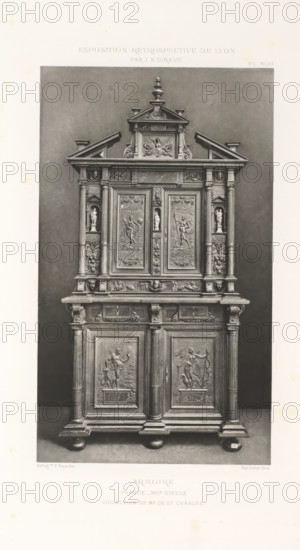 16th-century French wooden cabinet, at the Exposition Rétrospective of 1877 in Lyon, France, photomechanical print, This print is part of a cover with 79 prints on 54 sheets and 65 text sheets., inscription: 'ARMOIRE, FRANCE_XVIe SIÈCLE, COLLECTION DE Mr DE St CHARLES.', inscription: 'EXPOSITION RÉTROSPECTIVE DE LYON, PAR JB GIRAUD.', number: 'PL. XLIII.', photographer: Jacques Garcin, Lyon, cliché maker: Dujardin, printer (person): Imprimerie Eudes, Paris, 1877 - 1878, printer (person), paper, photoaquatint, height 463 mm x width 313 mm, ornamental cupboard (wood and other phytogenic material), A tall ornate wooden cabinet stands against a plain dark background, featuring an upper section with a triangular pediment topped by a finial and intricate carved detailing including scrollwork and a central relief panel, flanked by small pilasters and recessed niches each holding a small sculpted figurine; below this the central doors display carved panels with figural scenes framed by decorat...