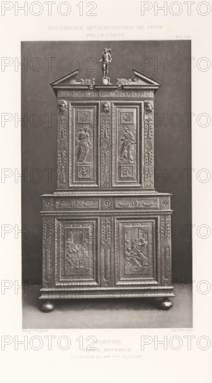 17th-century French wooden cabinet, at the Exposition Rétrospective of 1877 in Lyon, France, photomechanical print, This print is part of a cover with 79 prints on 54 sheets and 65 text sheets., number: 'PL. LIII.', inscription: 'EXPOSITION RÉTROSPECTIVE DE LYON, PAR JB GIRAUD.', inscription: 'ARMOIRE, FRANCE_XVIIe SIÈCLE, COLLECTION DE Mme Vve ROUGIER.', photographer: Jacques Garcin, Lyon, cliché maker: Dujardin, printer (person): Imprimerie Eudes, Paris, 1877 - 1878, printer (person), paper, photoaquatint, height 463 mm x width 313 mm, ornamental cupboard (wood and other phytogenic material), A tall ornate wooden cabinet with decorative panels and carved reliefs stands on rounded bun feet against a plain dark backdrop; the upper section has a pediment with scrollwork and a small sculpture of a standing figure atop the center, flanked by carved faces and pilasters with floral and foliate motifs, while the doors and panels display framed bas-relief scenes of draped figures and ornament...