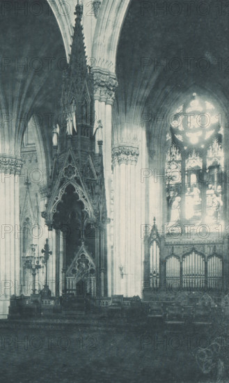 Saint Patricks Cathedral, New York, Altar and lectern in Saint Patrick's Cathedral in New York, page, photomechanical print, inscription: 'Altar, Bishops Throne', cliché maker: Lakeside Press, publisher: Haskell & Post Publishers, c. 1881 - in or before 1886, Lakeside Press, Haskell & Post Publishers, photographer, cliché maker, publisher, paper, collotype, photoprint, height 300 mm x width 425 mm, altar, bishop's throne, North America, Saint Patrick's Cathedral (New York), A rotated photograph of an ornate interior showing tall arched ceilings and elaborate carved columns topped with decorative capitals, a large circular stained glass window with bright panes, patterned vertical windows, and an elevated carved wooden structure with pointed arches and intricate tracery above a darkened platform area; pale walls and draped curtains form the backdrop and a wide pale border surrounds the image.