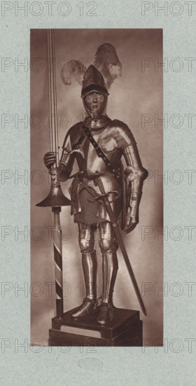 16th-century armor with lance and sword from the army of Henry II of France, from the collection of the Musée d'Artillerie in Paris, photomechanical print, This print is part of a cover with 36 prints, a title page and a list of images., check stamp: 'PHOTOGLYPTIE, LEMERCIER ET Cie, PARIS', Paris, cliché maker: Lemercier & Cie., c. 1877 - in or before 1882, Lemercier & Cie., photographer, cliché maker, paper, Woodburytype, Woodburytypie, height 275 mm x width 115 mm, hacking and thrusting weapons: sword, armour, helved weapons, polearms (for striking, hacking, thrusting): lance, A full-length figure in a suit of polished plate armor stands on a rectangular wooden pedestal, wearing a helmet with a pointed visor and large plume feathers rising above it, with a closed gauntleted hand gripping the shaft of a long pole weapon that rests on a circular guard, while the other hand hangs near the hilt of a sheathed sword at the waist; the armor includes articulated pauldrons, a breastplate with...