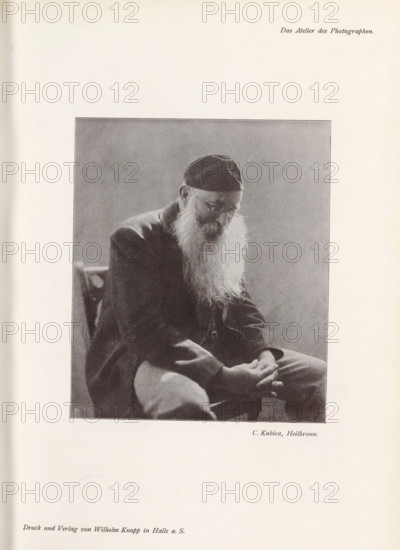 Portrait of an unknown man, page, photomechanical print, inscription: 'Das Atelier des Photographen.', monogram: 'LEIPZIG, S G', photographer: Curt Kubica, Heilbronn, cliché maker: unknown, Leipzig, printer (person): Wilhelm Knapp, Halle an der Saale, c. 1895 - in or before 1900, printer (person), Baden-Württemberg, Saxony-Anhalt, Saxony, paper, autotypie, height 142 mm x width 120 mm, historical persons, A grayscale photograph of an elderly man seated and leaning forward, wearing a dark cap and a dark jacket, with a long white beard flowing over his chest; his head is bowed and his eyes are partly obscured by glasses, his hands rest together in his lap, and a simple chair back is visible behind him against a plain background.