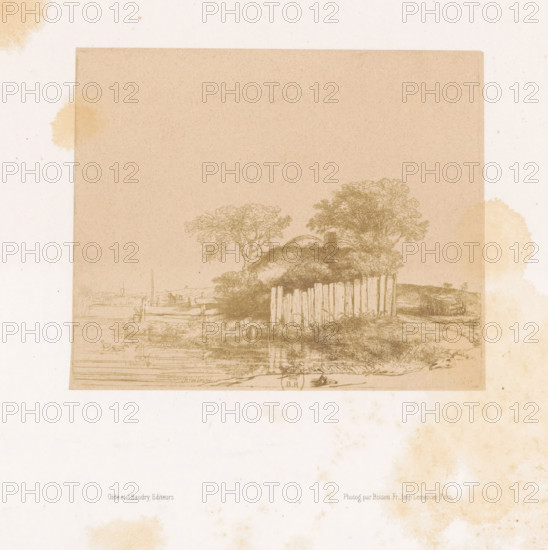 Photo reproduction of an etching of a farm with a white plank fence by Rembrandt van Rijn, photograph, reproduction, page, photographer: Bisson Frères, after print by Rembrandt van Rijn, printer (person): Lemercier, Paris, publisher: Gide et J. Baudry, c. 1848 - in or before 1853, Rembrandt van Rijn, after print by, printer (person), paper, salted paper print, height 130 mm x width 158 mm, farm or solitary house in landscape, A faded rectangular print with a light brown tone sits near the top of a pale sheet, showing a rural scene with a cluster of trees and a thatched structure behind a vertical wooden fence, reflections of the landscape visible along a horizontal waterline, faint outlines of boats and shore details at the water's edge, and irregular pale brown stains scattered around the sheet edges.
