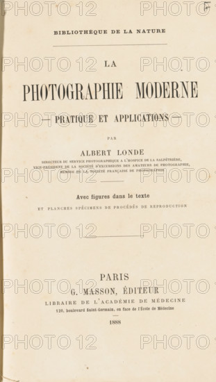 La photographie moderne : pratique et applications, book, number: '5562', date: 'AUG 1995', number: '1800', bookplate: 'H. van Ommeren, Paramaribo - Suriname', publisher: Georges Masson, Paris, 1888, textile materials, pasteboard, biological material, paper, linen (material), leather, transparent paper, printing, collo-autotypie, photoaquatint, collotype, height 252 mm x width 170 mm x thickness 30 mm, A vertically oriented aged paper page with a narrow dark margin on the left, displaying multiple lines of printed text in varying large and small serif fonts, centered across the page with horizontal dividing lines and some small decorative marks, the paper showing light brown foxing spots and slight discoloration around the edges.