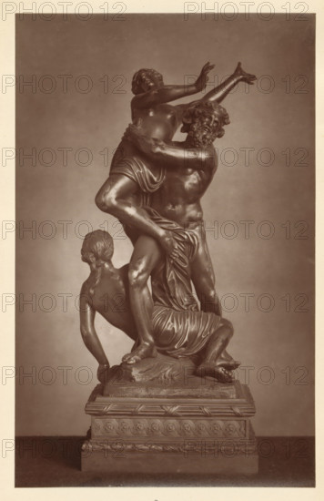 Bronze statue of the robbery of Proserpina, from the collection of Christopher Beckett Denison, page, photomechanical print, number: '805', c. 1880 - in or before 1885, paper, Woodburytype, height 194 mm x width 122 mm, Print on third unnumbered page after page 78., the rape of Proserpina (by Pluto in his chariot), possibly with Diana and Minerva trying to rescue her, piece of sculpture (precious metals, arts), A monochrome photograph of a multi-figure sculpture mounted on a decorative rectangular pedestal, showing three intertwined human figures rendered in a smooth, reflective material. One figure stands centrally, muscular with a bearded face turned sideways and arms lifting another figure who is elevated with arms raised and head tilted back, torso partially draped. A third figure kneels at the base, turned away with hair gathered at the nape and one arm extended downward, supporting the composition. Drapery folds wrap around hips and legs of the figures, and the pedestal features ...