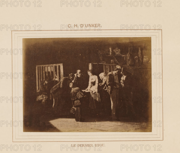 Photo reproduction of Le dernier byou by Carl Henrik D'Unker, Le dernier byou, photograph, reproduction, page, inscription: 'CH D'Unker', after painting by Carl Henrik D'Unker, c. 1878 - in or before 1883, Carl Henrik D'Unker, photographer, paper, albumen print, albumendruk, height 96 mm x width 131 mm, painting, drawing and the graphic arts, A sepia-toned print mounted on a pale page shows a dimly lit indoor scene with a group of people gathered around a central table. The group includes figures bending and standing, some wearing simple period clothing and one woman in a lighter dress leaning toward the table. A small child stands in the foreground holding a round object. The background contains wooden railings and indistinct interior elements, with darker shadows framing the scene and a lighter patch of floor in front of the group. The print is surrounded by decorative rectangular borders on the page.