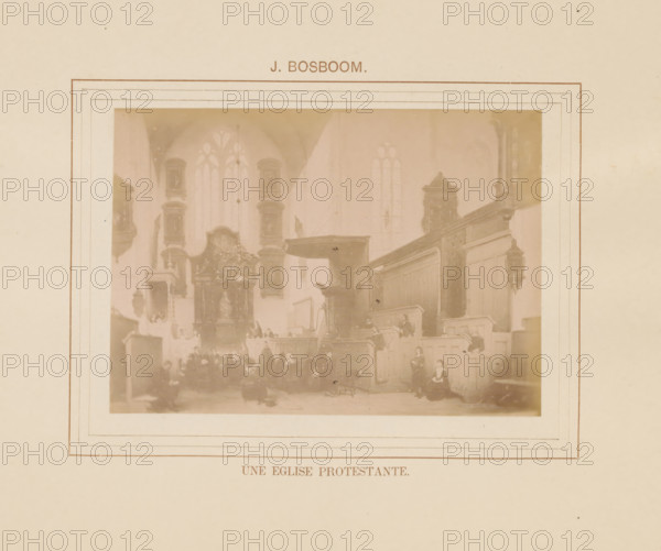 Une eglise protestante, Photo reproduction of Une eglise protestante by Johannes Bosboom, photograph, reproduction, page, inscription: 'J. Bosboom', after painting by Johannes Bosboom, c. 1878 - in or before 1883, photographer, paper, albumen print, height 92 mm x width 128 mm, interior of church, painting, drawing and the graphic arts, A faded photographic print mounted on a larger sheet with a rectangular decorative border, showing an interior scene with tall arched windows, wooden paneling, elevated pulpit area, ornate altarpiece with a statue, hanging chandelier, several seated and standing figures wearing period clothing, and muted sepia tones throughout.