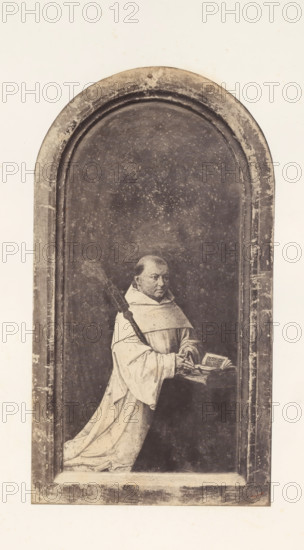 Photo reproduction of Robrecht de Clercq, abbot of Ter Duinen, photograph, reproduction, page, photographer: Edmond Fierlants, after painting by anonymous, publisher: C. Muquardt, Brussels, c. 1856 - in or before c. 1861, paper, albumen print, albumendruk, height 378 mm x width 206 mm, monk(s), friar(s), one person praying, A vertical rectangular image with an arched, recessed panel occupying most of the frame, showing a monochrome scene of a robed figure kneeling on a ledge inside the arch. The figure wears a light-colored hooded robe with long flowing sleeves and holds an open book resting on a small lectern or stand, one hand touching the pages. A long staff or rod with a textured top rests against the figure’s shoulder and extends upward. The background inside the arch is dark and speckled, with visible wear and mottling, while the arch and surrounding border show scratches, scuffs, and spots of discoloration. The outer margins are light and plain, contrasting with the darker inter...