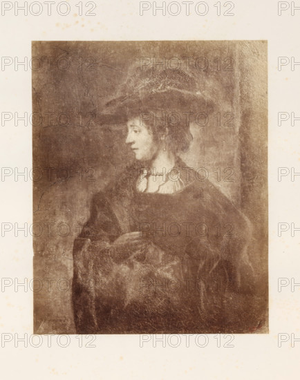Photo reproduction of Saskia van Uylenburgh by Rembrandt van Rijn, photograph, reproduction, page, photographer: Edmond Fierlants, after painting by Rembrandt van Rijn, publisher: C. Muquardt, Brussels, c. 1856 - in or before c. 1861, paper, albumen print, height 352 mm x width 281 mm, Person, Saskia van Uylenburgh, historical persons - BB - woman, A sepia-toned portrait of a person shown from the waist up facing left, wearing a wide-brimmed hat and a dark robe with a lighter collar, with an earring visible on the left ear and one hand resting near the chest; the image shows visible crackling and aged texture across the surface and a lighter border surrounding the portrait.