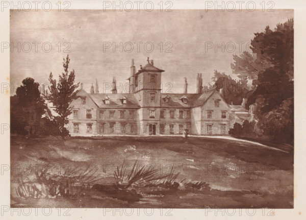 Photo reproduction of a painting depicting a view of Toft Hall in Cheshire, reproduction, page, photomechanical print, cliché maker: Woodbury Permanent Photographic Printing Company, after painting by anonymous, c. 1866 - in or before 1876, photographer, paper, Woodburytype, Woodburytypie, height 90 mm x width 129 mm, rural housing, eg country-house, villa, cottage, façade (or house or building), A sepia-toned image of a large, multi-story manor house centered in the frame, with a taller square tower rising above the central section and pitched roofs with dormer windows flanking it; rows of rectangular windows and a central doorway are visible along the facade. The house is set behind a gently sloping lawn in the foreground, with clumps of low grasses and darker textured ground closer to the viewer. Tall trees and shrubbery frame the building on both sides, with a denser stand of trees on the right and a pair of taller, narrower trees on the left. The sky above is pale and evenly toned...