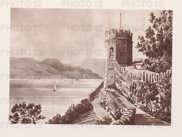 Photographic reproduction of a painting, depicting a view of a stone tower, with a lake in the background, reproduction, page, photomechanical print, cliché maker: Woodbury Permanent Photographic Printing Company, after painting by Augustus Hare, c. 1866 - in or before 1876, photographer, paper, Woodburytype, Woodburytypie, height 83 mm x width 117 mm, lake, tower, clock tower, monumental adornment, A sepia-toned scene shows a stone tower with battlements and a narrow window rising beside a curved stone wall and pathway that follow the cliff edge, with trees and dense foliage along the right side and lower foreground; beyond the wall a body of water stretches toward distant hills, with several small sailboats on the water and a calm sky above.