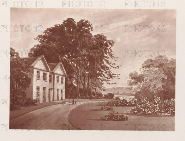 Photographic reproduction of a painting, depicting a view of the Stoke vicarage, reproduction, page, photomechanical print, cliché maker: Woodbury Permanent Photographic Printing Company, after painting by Catherine Leycester, Stoke, c. 1866 - in or before 1876, photographer, Cheshire (county), paper, Woodburytype, Woodburytypie, height 84 mm x width 116 mm, organizations, assemblies, etc. in Protestant churches, façade (of house or building), A sepia-toned scene showing a two-story house with gabled roof and tall windows partially obscured by large leafy trees, a curved paved road leading past the house toward a distant body of water, expanses of shrubs and landscaped planting beds along the roadside, dense tree canopies framing the right side, and a cloudy sky overhead.