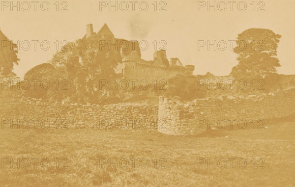 Craigmillar, View of Craigmillar Castle, photograph, page, number: 'Pl. 2.', photographer: Vincent Brooks, Day & Son, Edinburgh, c. 1864 - in or before 1874, paper, albumen print, height 77 mm x width 119 mm, castle, Craigmillar Castle, A faded sepia-toned photograph shows an old stone wall running horizontally across a grassy foreground, with a low stone pillar interrupting the wall near the center. Behind the wall, there are dense trees and foliage partially obscuring the outline of a ruined stone building with crenellated walls and angled rooflines. A large, rounded tree stands to the right of the building, and additional trees and vegetation frame the left side. The sky above is pale and mostly empty, and the image has a worn, aged appearance with uneven toning.