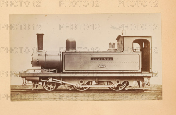 Passenger steam locomotive made by Sharp, Stewart and Company, photograph, page, inscription: 'Class 816. Passenger tank engine', c. 1874 - in or before 1884, photographer, paper, albumen print, height 83 mm x width 143 mm, steam locomotive, A sepia-toned photograph of a small steam locomotive shown in profile on a pale background, with a cylindrical boiler and a tall narrow chimney at the front, a rounded dome midway, and a rectangular tank section behind with riveted metal panels. The locomotive sits on visible driving wheels and connecting rods beneath a flat running plate, with exposed mechanical linkages and suspension elements. At the rear there is an open cab with a rounded doorway and a small handrail, and on the top of the tank near the cab are cylindrical fittings and a rectangular raised housing. The image has a textured paper border and small specks and blemishes across the background.