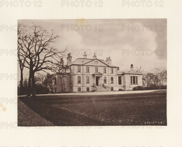 Craigton, photograph, page, photographer: Thomas Annan, Scotland, c. 1868 - in or before 1878, paper, carbon print, height 115 mm x width 160 mm, rural housing, eg country-house, villa, cottage, façade (or house or building), A large classical house with a symmetrical façade and a central pediment sits on a raised terrace with a flight of steps leading to an entrance with columns, flanked by tall windows and chimneys on the roof; a bare-branched tree is prominent in the foreground to the left, casting a shadow across a gravel drive and a lawn that stretches toward the house, while additional leafless trees frame the scene against a cloudy sky.