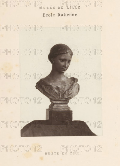 Wax bust of a woman, Bust en cire, page, photomechanical print, inscription: 'Musée de Lille Ecole Italienne', Lille, printer (person): Goupil & Cie., c. 1862 - in or before 1872, printer (person), paper, Woodburytype, height 117 mm x width 88 mm, Print opposite title page., chest, bust - AA - female human figure, A photographic print of a sculpted bust of a young woman mounted on a pedestal, shown from the shoulders upward, with her head slightly tilted and hair styled close to the head; the bust displays a draped garment across the shoulders and chest, and the pedestal has a stepped rectangular base sitting on a draped cloth surface, all presented against a pale background within a border on an aged, slightly spotted paper.