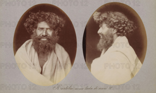 Karteben, uomo toda di anni 30, Two portraits of Karteben of the Toda tribe, photograph, page, photographer: Paolo Mantegazza, India, c. 1881 - in or before 1886, paper, albumen print, height 151 mm x width 241 mm, adult man (side view, profile), Two oval sepia photographs mounted on a gray background showing the same bearded man from different angles; the left oval is a frontal view of a man with dark curly hair and a thick beard wearing a light draped cloth over his shoulders, his eyes visible and his face framed by hair and beard; the right oval is a profile view of the same man turned to the side, showing his curly hair, beard, and the draped cloth from a different angle.