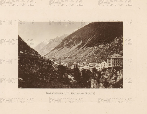 View of Göschenen in Switzerland, Göschenen (St. Gothard Route), page, photomechanical print, c. 1874 - in or before 1884, paper, collotype, photogravure, height 82 mm x width 127 mm, city-view in general, 'veduta', mountains, A sepia toned photograph framed by a wide cream border shows a mountainous valley with steep, rocky slopes and forested ridges; at the bottom of the valley a small village with clustered buildings including a multi-story structure and a church with a pointed tower sits beside a stone arch bridge spanning a gorge, and distant snow-capped peaks are visible under a pale sky.