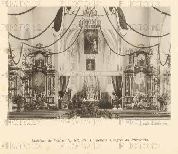 Interior of the L'Eglise des Cordeliers in Fribourg, Intérieur de l'église des RR. PP. Cordeliers (Congès du Piusverein), page, photomechanical print, maker: Ernest Lorson, Fribourg, maker: SADAG, 1897, paper, collotype, photoprint, height 111 mm x width 162 mm, interior of church, A black-and-white photograph of a church interior showing a central altar framed by ornate side altarpieces and tall arched ceilings, with garlands draped across the nave and a large chandelier hanging above; rows of wooden pews lead toward the altar, flanked by decorative columns, statues, paintings within carved frames, and potted plants, while curtains and an elaborately detailed reredos occupy the area behind the altar and two small figures are seated near the front pews.