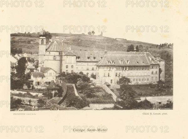 Collège Saint-Michel, View of the Collège Saint-Michel in Fribourg, page, photomechanical print, maker: Ernest Lorson, Fribourg, maker: SADAG, 1897, paper, collotype, photoprint, height 112 mm x width 162 mm, university building, college, A sepia-toned photograph of a hillside town showing a cluster of masonry buildings with pitched roofs and dormer windows, including a prominent large building with a steep tiled roof and rows of shuttered windows, and a rounded tower with a conical roof and a square bell tower adjacent to it; surrounding structures include smaller houses, chimneys, and gardened plots with trees and hedges, while the foreground shows stone walls and terraces and the background reveals rolling grassy hills dotted with a few isolated trees under a pale sky.