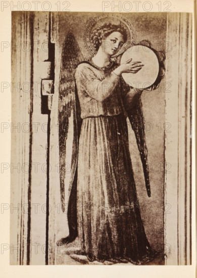 Photo reproduction of a detail of the Tabernacolo dei Linaioli by Fra Angelico, depicting an angel with a tambourine, photograph, reproduction, page, Italy, after painting by Fra Angelico, c. 1850 - in or before 1860, photographer, paper, albumen print, height 134 mm x width 97 mm, angels, tambourine, A sepia-toned image of a standing angel with a halo, long curly hair, and feathered wings, wearing a long flowing robe with pleats and holding a round, flat object with both hands near chest level; the angel's head is slightly tilted and the facial expression is calm, the wings extend down past the waist, and the figure is framed by vertical architectural elements on either side with visible worn textures and shadows.