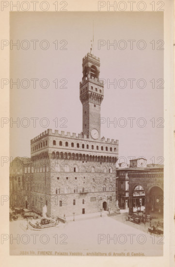 Exterior of the Palazzo Vecchio in Florence, Florence. Palazzo Vecchio, architettura di Arnolfo di Cambio, photograph, page, number: '3034bis.', photographer: Edizioni Brogi (possibly), Florence, c. 1878 - in or before 1888, Tuscany, paper, albumen print, height 148 mm x width 94 mm, façade (of house or building), hôtel, ie small palace in city, Palazzo Vecchio, A sepia-toned photograph of a large stone palace with a tall rectangular tower rising from its center, the tower topped by a crenellated parapet and an open belfry with arches and a slender vertical rod extending upward. The palace façade shows rows of arched windows and decorative battlements along the roofline, with a large circular clock face mounted on the tower above the main body. In front of the palace is a courtyard area with a sculpted fountain featuring a central statue on a raised basin surrounded by low railings. To the right of the palace an arched loggia and adjoining buildings form a street scene with people and ...