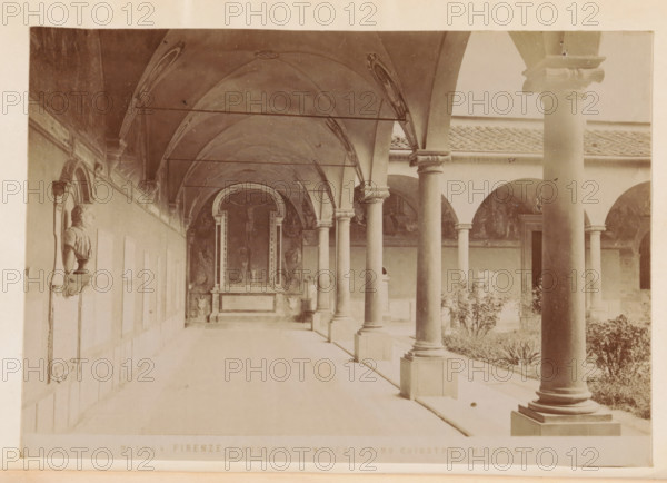 Firenze - Museo di S. Marco. primo chiostro (Michelozzi), Cloister of the San Marco Monastery in Florence, photograph, page, number: 'No 1344', Florence, c. 1880 - in or before 1890, photographer, Tuscany, paper, albumen print, height 97 mm x width 140 mm, cloisters, monastery, San Marco, A long, covered stone walkway lined with tall round columns supporting arches and a vaulted ceiling with decorative painted ribs runs beside a courtyard with plants and low walls; along the left wall a sculpted bust set in a framed niche is mounted above a small pedestal, and at the far end of the walkway a framed altar or niche with sculpted figures and ornate borders is visible beneath the vaulted arch.