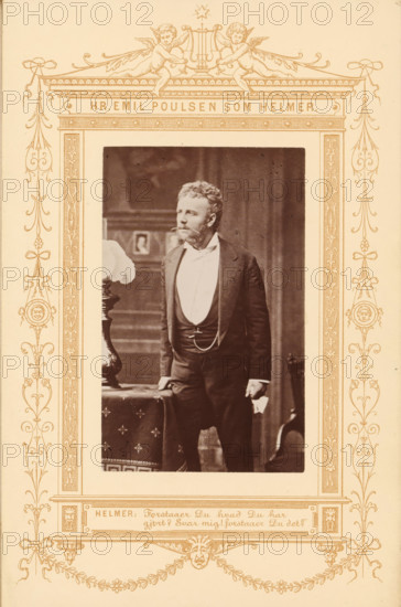 Hr. Emile Poulsen som Helmer, Portrait of the actor Emil Poulsen as Helmer in A Doll's House, photograph, page, inscription: 'Helmer:, Du det?', photographer: JA Schulz, printer (person): Edvin Jantzen, publisher: Ernst Bojesen, c. 1870 - in or before 1880, JA Schulz, Edvin Jantzen, Ernst Bojesen, photographer, printer (person), publisher, paper, albumen print, albumendruk, height 94 mm x width 60 mm, Person, Emil Poulsen, portrait of actor, actress, A sepia photograph shows a man standing indoors, dressed in a dark suit with a waistcoat and a white shirt, his hand resting on a table draped with a patterned cloth and the other hand holding a folded item; he has a beard and curly hair and looks slightly to his left. The framed portrait is set within an ornate decorative border featuring symmetrical floral and scroll motifs, medallion faces, ribbon-like elements, and two cherubs at the top holding a lyre, all rendered in a single ink color against a light background. The interior backgro...