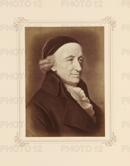 Photo reproduction of a portrait of Christoph Martin Wieland, photograph, reproduction, page, photographer: Friedrich Bruckmann (possibly), after painting by Anton Graff (possibly), c. 1868 - in or before 1878, paper, albumen print, height 154 mm x width 110 mm, Person, Christoph Martin Wieland, writer, poet, author, A sepia-toned portrait of an older man shown from the shoulders up, wearing a dark coat with a high collar and a ruffled white cravat, with curly hair at the temples partly covered by a dark cap, a solemn facial expression with visible wrinkles around the eyes and forehead, and a neutral background; the portrait is set within a decorative bordered mount with simple ornamental corner flourishes on a pale paper.