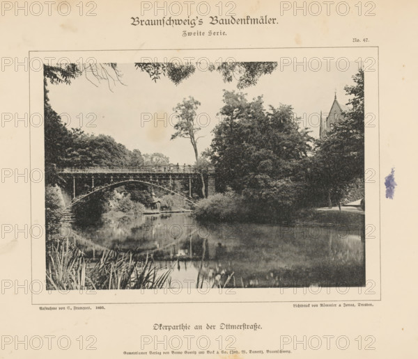 Pond in a park in Braunschweig, Oferparthie an der Ottmerstraße, Braunschweig's Baudenkmäler, page, photomechanical print, number: 'No. 47.', photographer: C. Franques, Braunschweig, cliché maker: Römmler & Jonas, Dresden, publisher: Benno und Wilhelm Danert Goeritz, 1893, C. Franques, Römmler & Jonas, Benno und Wilhelm Danert Goeritz, photographer, cliché maker, publisher, Lower Saxony, Saxony, paper, collotype, photoprint, height 107 mm x width 150 mm, public gardens, park, bridge, A sepia-toned printed page shows a rectangular framed photograph of a park scene with a metal arch bridge spanning a calm body of water, trees and foliage surrounding the bridge, a tall slender tree rising above the bridge, a small pavilion or boathouse at the water's edge beneath the bridge, reflections of trees and structures in the water, people visible on the bridge railing, dense tree canopies on either side, a pointed church tower peeking above trees at the right edge, overhanging branches along the ...
