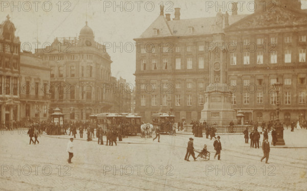 View of Dam Square with horse trams in Amsterdam, photograph, inscription: 'Mies Schürer Ruth', photographer: circle of Gerrit van der Mey, Amsterdam, c. 1890 - before 1895, paper, pasteboard, daylight gelatin silver print, height 76 mm x width 112 mm, height 99 mm, width 128 mm, Dam (Amsterdam), A wide street scene in a city with a large ornate building and a tall monument occupying the right side, a domed building and other multi-story facades on the left, horse-drawn trams and horses near the center, many people walking and standing across the paved square, a man pushing a seated person in a wheeled chair in the foreground, lampposts and small kiosk structures near the buildings, and cobblestone paving filling the open area.