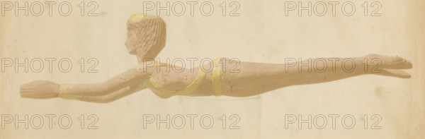 The carved wooden handle of an ancient Egyptian spoon, photograph, inscription: '1082, 7 (M v W)', inscription: 'Manche de cuillère en bois. Ancien Egyptien', photographer: attributed to Willem de Famars Testas, 1858 - 1860, Attributed to, paper, paint (coating), deck paint, salted paper print, salt print, colored with yellow body paint, height 83 mm x width 241 mm, spoon, A pale, elongated figurine of a person shown in profile, lying horizontally with arms extended forward and legs together, rendered in muted beige tones with subtle yellow accents on the headband, wristband, chest strap, and waist band, short textured hair, simplified facial features, and slight surface wear and imperfections visible against a neutral, lightly mottled background.
